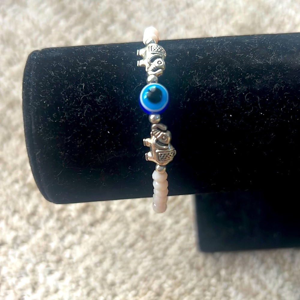 Evil eye bracelet with silver elephant charms and white czech beads
